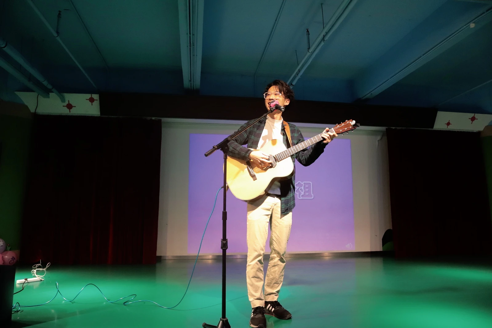 王於陞老師在舞台上彈奏吉他並演唱